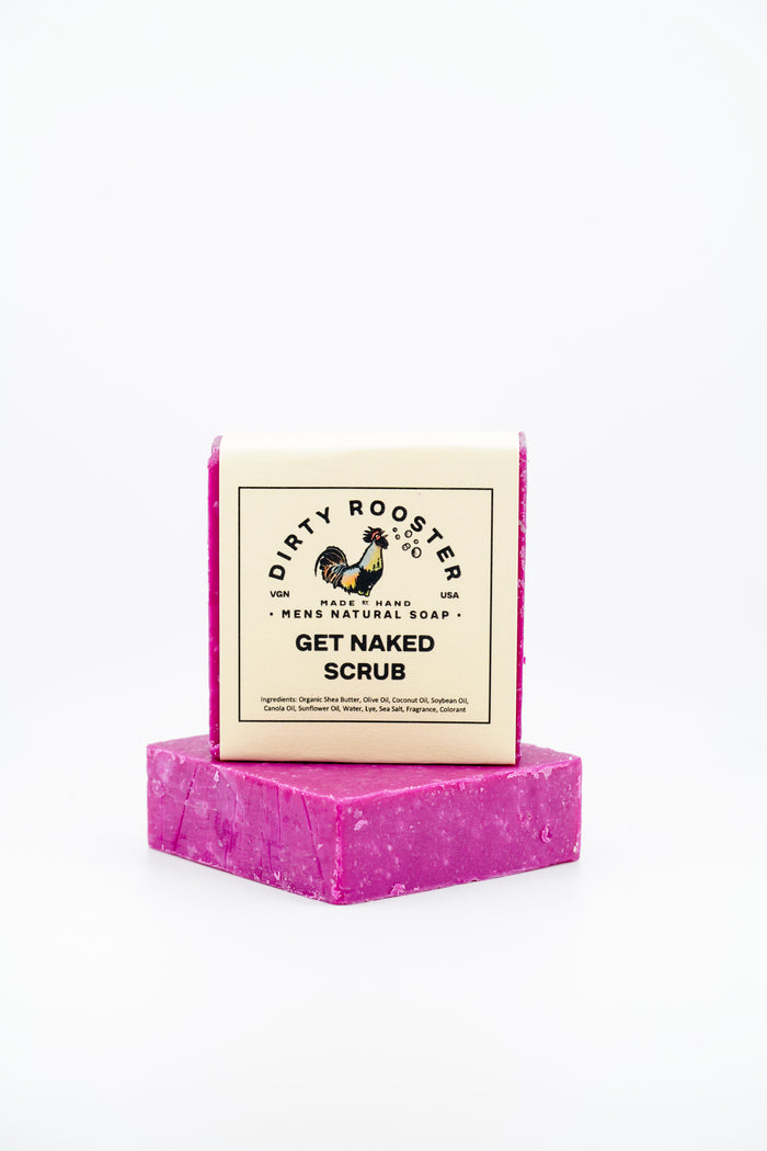 Get Nak3d Scrub handmade natural soap bar for men, wrapped, standing on an unwrapped hot pink bar