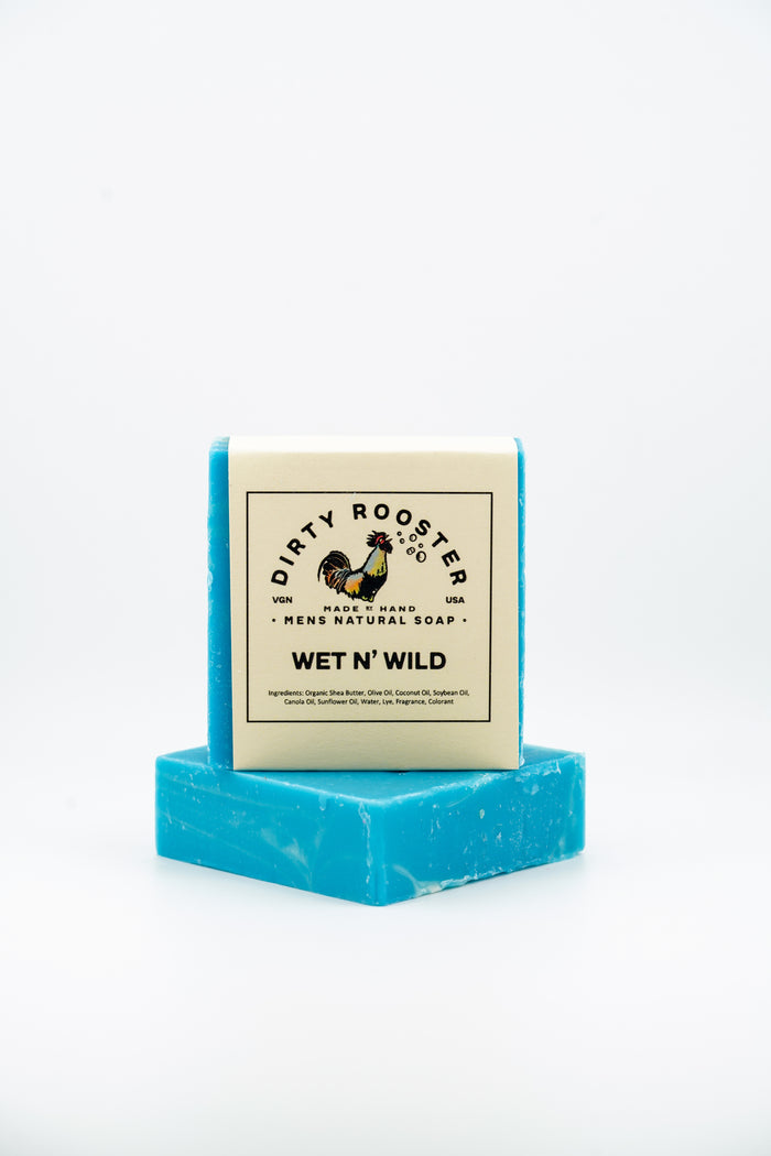 Wet N' Wild handmade natural soap bar for men, wrapped, standing on an unwrapped blue and white swirled bar