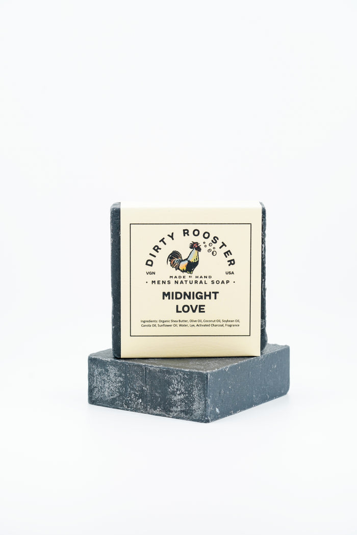 Midnight Love handmade natural soap bar for men, wrapped, standing on an unwrapped black bar