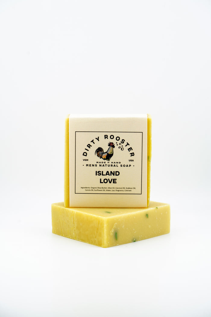 Island Love handmade natural soap bar for men, wrapped, standing on an unwrapped yellow bar