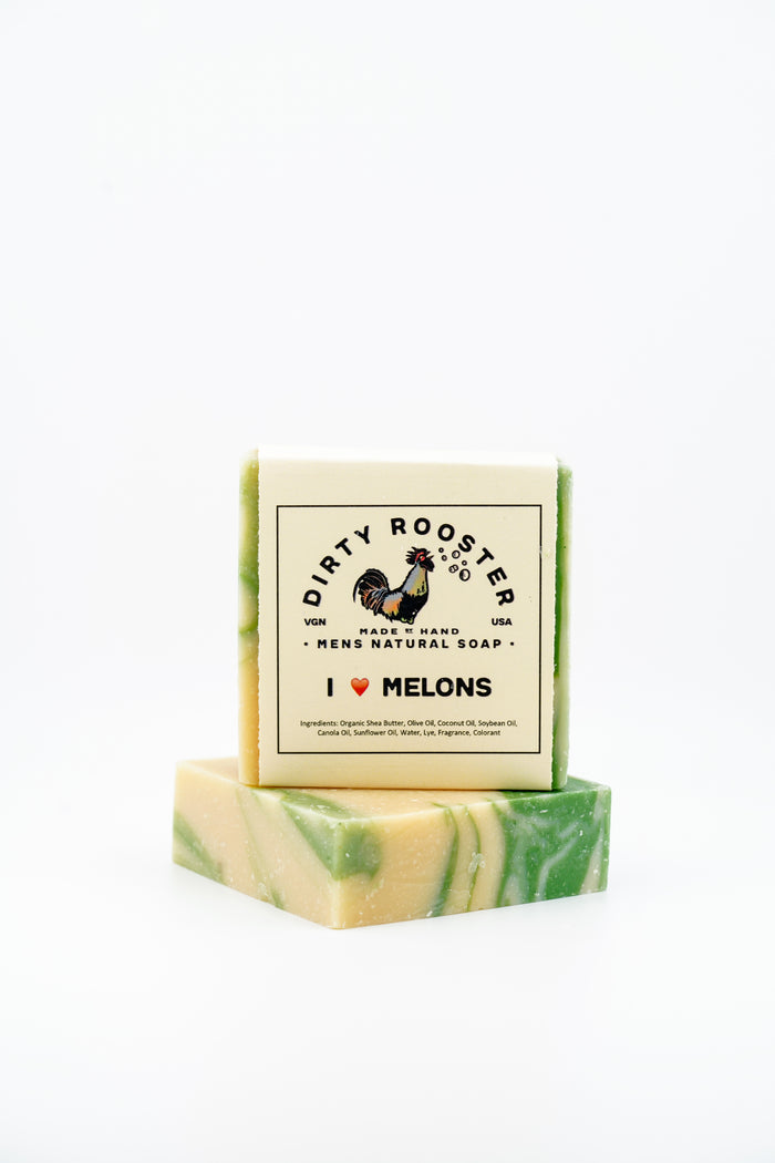 I Heart Melons handmade natural soap bar for men, wrapped, standing on an unwrapped cream and green swirled bar